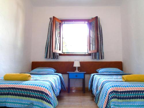 a room with two twin beds and a window at bungalow Las TARTANAS I I in Maspalomas