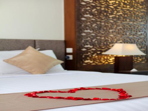 a red heart on a bed in a hotel room at Villa Kayu Raja in Seminyak
