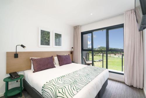 una camera con un letto e una grande finestra di Quest Springfield Central a Springfield Lakes