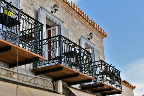 a building with balconies on the side of it at Guesthouse Corali in Hydra