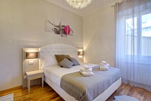 a bedroom with a white bed with towels on it at La Marmora Elegant in Florence