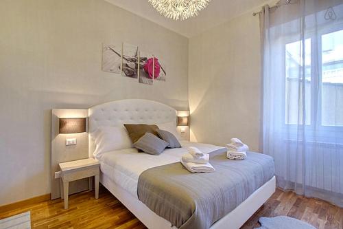 um quarto com uma cama branca e toalhas em La Marmora Elegant em Florença