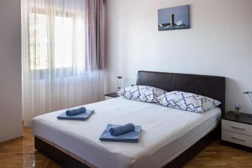 ein Schlafzimmer mit einem Bett mit zwei Handtüchern darauf in der Unterkunft Apartments Marijana in Senj