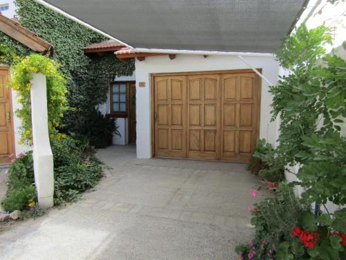 a house with a wooden garage door and some flowers at Calfulauquen in Las Grutas