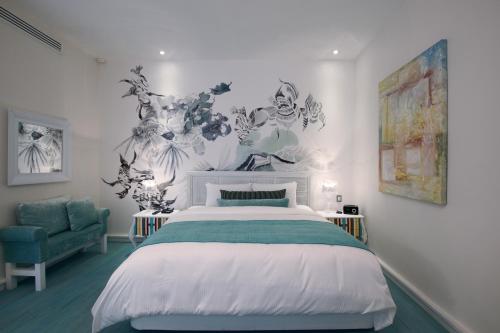 a bedroom with a bed and a blue chair at 1850 Hotel Boutique in Guanajuato