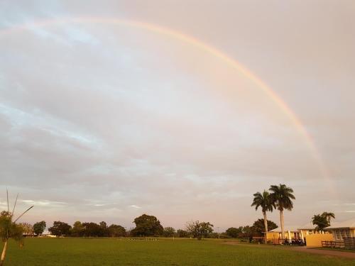 a rainbow in the sky over a field at Kernow - Minimum age 18 in Charters Towers