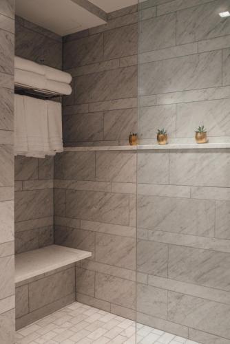 a bathroom with a shower with a glass wall at The Preston House and Hotel in Riverhead
