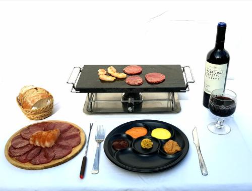 a table with a plate of food and a bottle of wine at Cabañas swissminiatur in Cacheuta