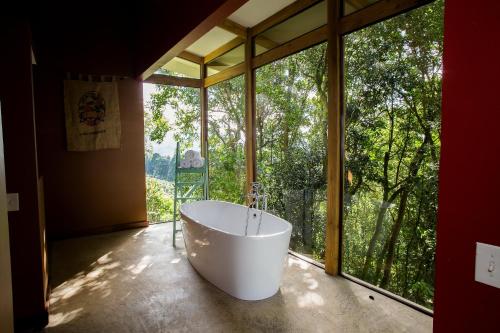 una vasca da bagno in una stanza con una grande finestra di Chayote Lodge a Zarcero