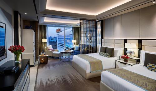 a hotel room with two beds and a balcony at Solaire Resort Entertainment City in Manila