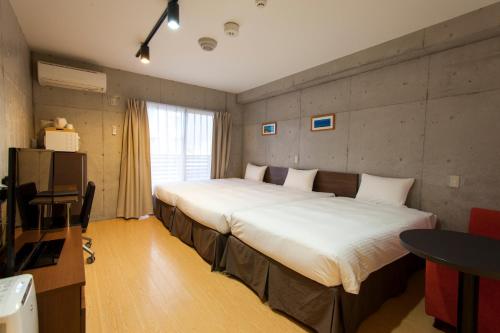 Postel nebo postele na pokoji v ubytování NAHA-WEST INN