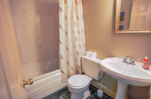 a bathroom with a toilet and a sink and a shower at The Woodview Inn in Gananoque