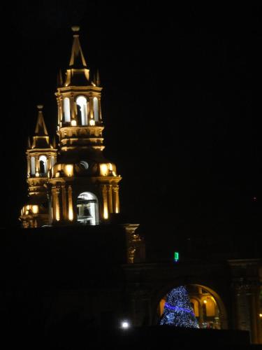 a building with a clock tower and a christmas tree at Hostal Qoyllurwasi in Arequipa
