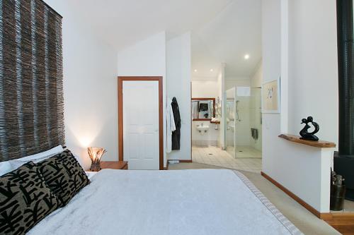 a bedroom with a large bed and a bathroom at Limpinwood Lodge in Limpinwood
