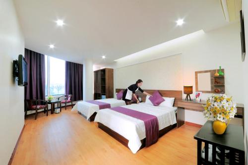 - un homme debout dans une chambre d'hôtel avec 2 lits dans l'établissement Van Giang Hotel, à Ninh Binh