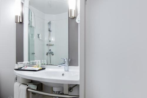 a bathroom with a sink and a mirror at Ibis Ambassador Myeongdong in Seoul
