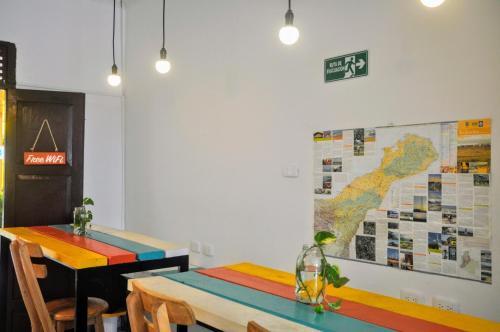 a room with two tables and a map on the wall at Bona Vida Hostel in Ríohacha