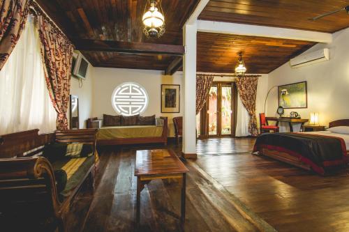 Terres Rouges Lodge في راتاناكيري: غرفة نوم مع سرير وغرفة معيشة