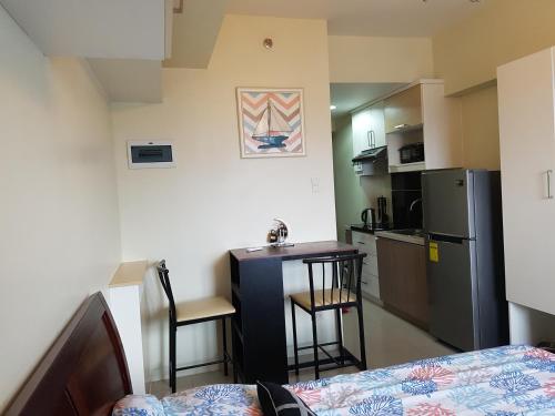 a small kitchen with a table and a refrigerator at KC Studio 5 at Horizon 101 Cebu in Cebu City