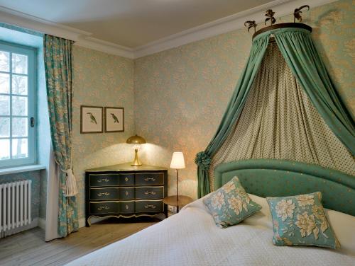 a bedroom with a bed with a canopy at Chateau De Germigney in Port-Lesney