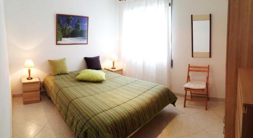 1 dormitorio con 1 cama, 1 silla y 1 ventana en Apartamento Praia de Altura-Terraço BBQ-Wfi-AC, en Altura