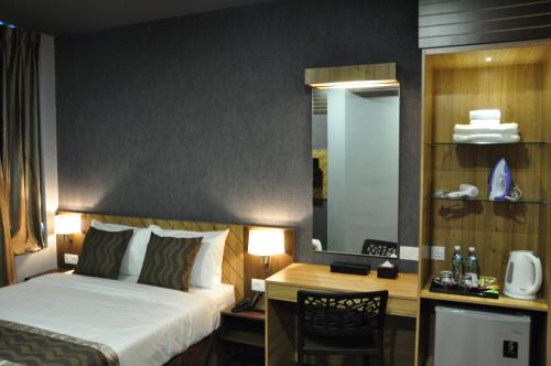 a hotel room with a bed and a desk at Valya Hotel, Kuala Terengganu in Kuala Terengganu
