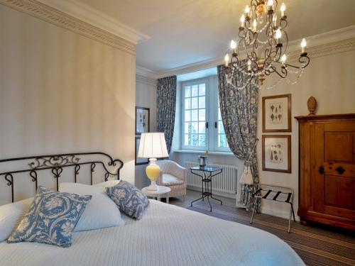 a bedroom with a bed and a chandelier at Chateau De Germigney in Port-Lesney
