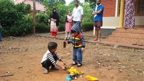 a couple of children playing with toys in the dirt at Marsim Holiday Resort in Vythiri