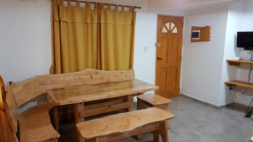 Habitación con banco de madera y mesa. en Brujas en Los Reartes