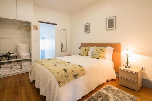 um quarto com uma grande cama branca num quarto em À Francos Love Lair 2 em Porto