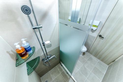 a shower with a glass door in a bathroom at Hu An Stay Hotel in Seogwipo