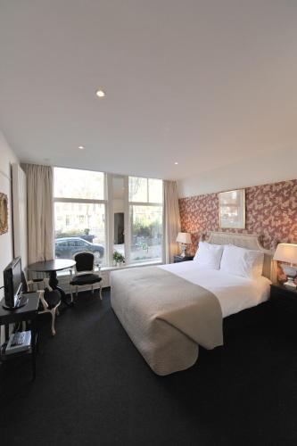 a bedroom with a large bed and a living room at The Posthoorn Amsterdam in Amsterdam