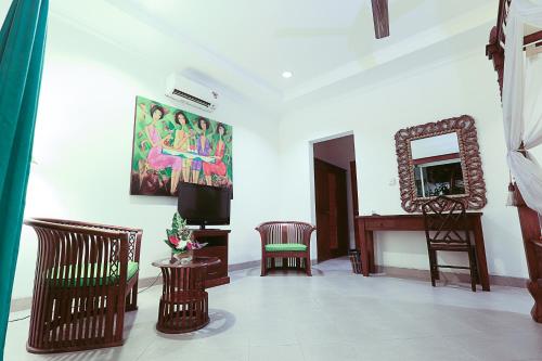 a living room with a tv and a mirror at Aquarius Beach Hotel in Sanur