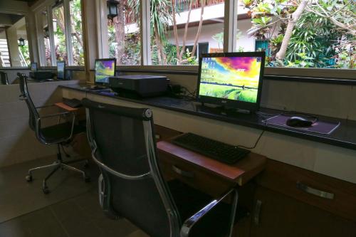 an office with three computer monitors on a desk at Aquarius Beach Hotel in Sanur