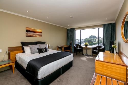 a hotel room with a bed and a desk at Plymouth International in New Plymouth