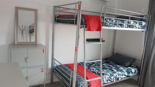 a room with two bunk beds and a mirror at Lisbon Hostel Terminal 3 in Lisbon