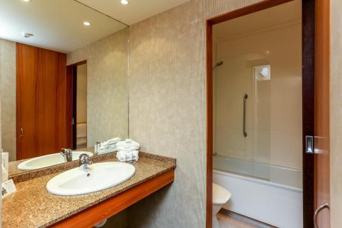 a bathroom with a sink and a toilet and a shower at Plymouth International in New Plymouth