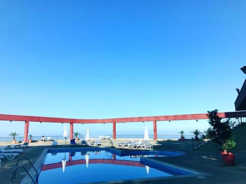 a swimming pool with a view of the ocean at Bzommar Palace Hotel in Harisa
