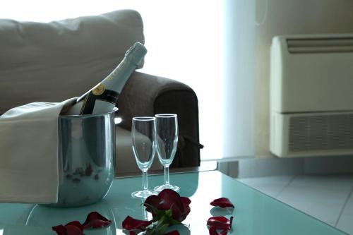 a bottle of champagne and two glasses on a table at Bzommar Palace Hotel in Harisa