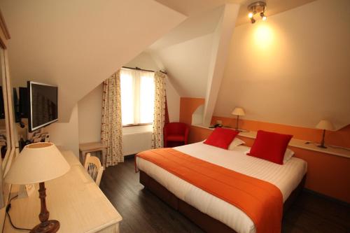 a hotel room with a bed with red pillows at Hotel La Roseraie in Wemmel