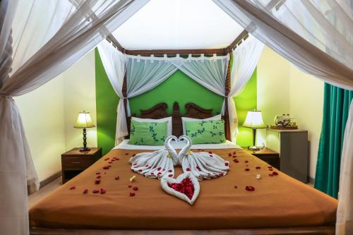 a bedroom with a bed with two hearts on it at Aquarius Beach Hotel in Sanur