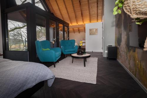 a bedroom with two blue chairs and a table at Bed & breakfast Hoeve Springendal in Hezingen