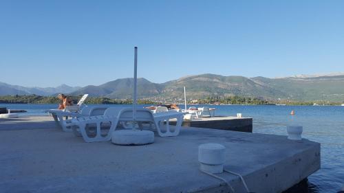 a group of chairs sitting on a dock next to the water at Apartments Klakor PS in Tivat