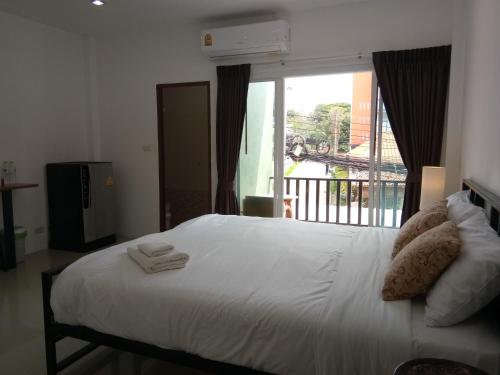una camera da letto con un grande letto bianco e una finestra di The Wang a Chalong