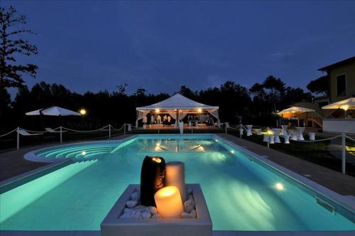 ein Schwimmbad in der Nacht mit Kerzen darin in der Unterkunft Hotel Vedute in Fucecchio