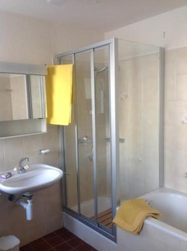 a bathroom with a shower and a sink and a tub at Casa Vacanza Ponte Aino in Poschiavo