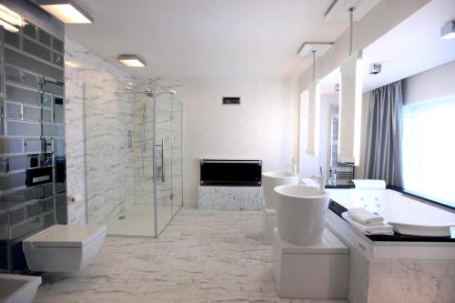 a bathroom with two sinks and a tub and a shower at Hotel & Medi-Spa Biały Kamień in Świeradów-Zdrój