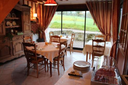 een eetkamer met een tafel en stoelen en een raam bij B&B DeValpierre adult only in Glanville