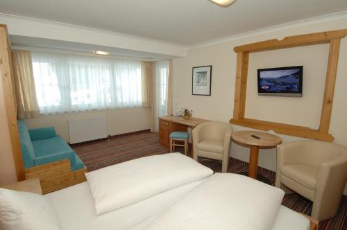 a living room with a white couch and a table at ARBOR Hotel & Apartments in Saalbach Hinterglemm