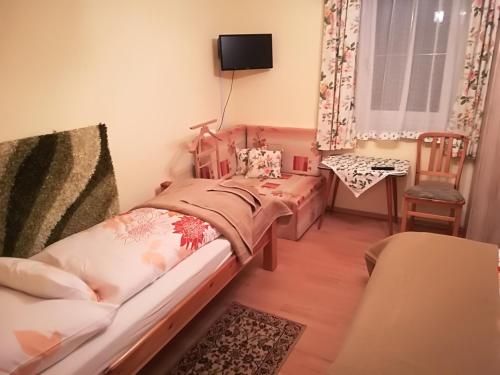 a small bedroom with a bed and a chair at Paul-S Apartman in Bad Hofgastein